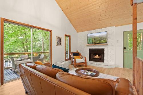 sala de estar con sofá y chimenea en Cozy Mountain Chalet With Hot Tub Outdoor Movie Screen And Fire Place, en Banner Elk