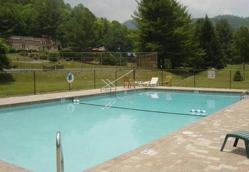 a large blue swimming pool in a yard at Cozy Mountain Chalet With Hot Tub Outdoor Movie Screen And Fire Place in Banner Elk