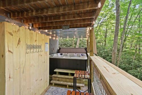 a jacuzzi tub sitting on a wooden deck at Cozy Mountain Chalet With Hot Tub Outdoor Movie Screen And Fire Place in Banner Elk
