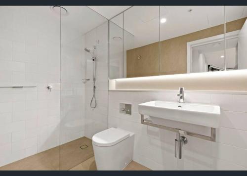 La salle de bains est pourvue de toilettes, d'un lavabo et d'une douche. dans l'établissement Sydney CBD Luxury Furnished Apartment & City Views, à Sydney