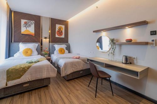a hotel room with two beds and a desk at Stay.vie Hotel in Surabaya