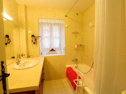 uma casa de banho com um lavatório, um chuveiro e uma banheira em Appartement Biron, 2 pièces, 2 personnes - FR-1-616-122 em Biron
