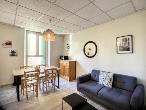 un salon avec un canapé et une table dans l'établissement Charmant F3 avec terrasse, à 2 pas des thermes et du centre, animaux acceptés, wifi inclus - FR-1-451-169, à Lamalou-les-Bains