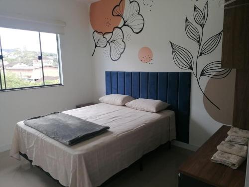 a bedroom with a bed with a blue head board at Confort Class GD II in Pomerode