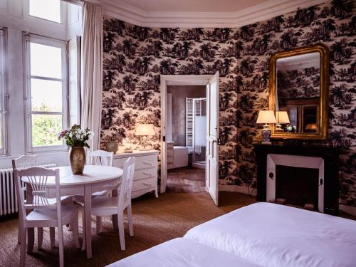 sypialnia z łóżkiem, stołem i lustrem w obiekcie Grand Château Renaissance avec Parc, Piscine et Activités, Rénové en 2023 - FR-1-410-389 w mieście Vallon-sur-Gée