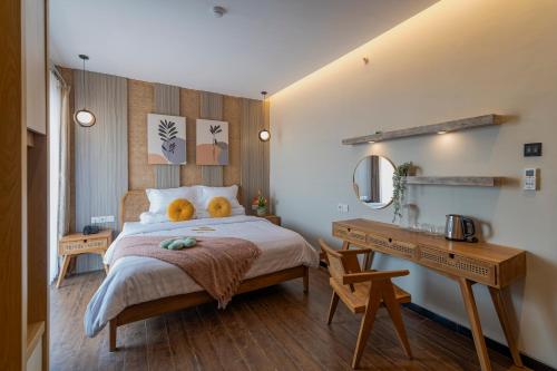 Stay.vie Hotel في سورابايا: غرفة نوم بسرير كبير مع مكتب ومغسلة