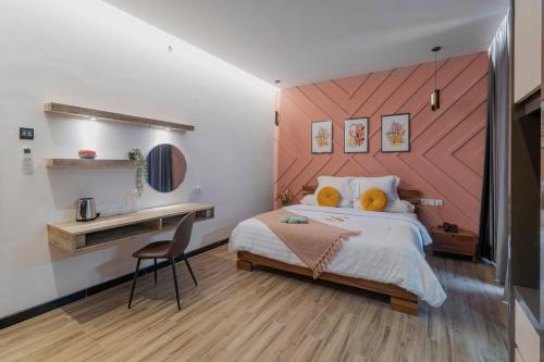 a bedroom with a large bed and a desk at Stay.vie Hotel in Surabaya