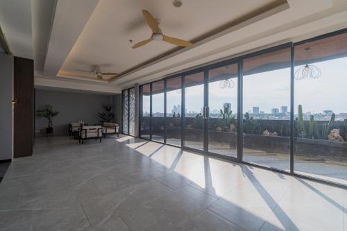 a living room with a ceiling fan and large windows at Stay.vie Hotel in Surabaya