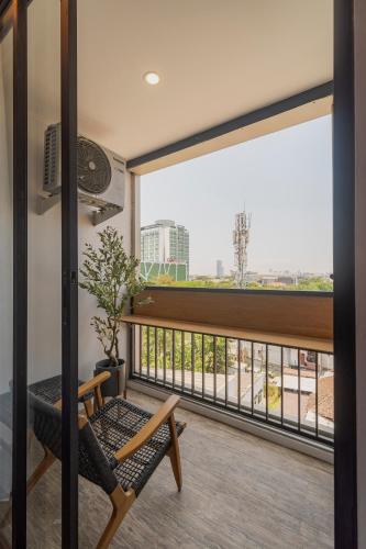 a balcony with a chair and a large window at Stay.vie Hotel in Surabaya