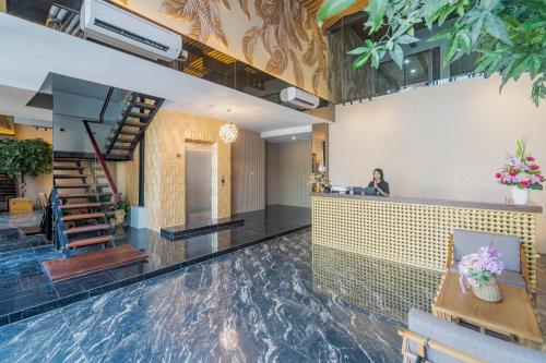 a lobby with a woman sitting at a counter at Stay.vie Hotel in Surabaya