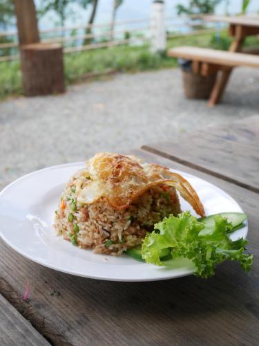 un plato de comida con arroz y lechuga en una mesa en Camping Park Resort en Kampong Speu