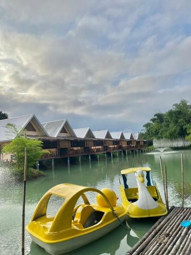 a yellow boat in the water next to a resort at เชียงคานพาราไดร์รีสอร์ท&มีตติ้ง in Ban Na Bon (1)