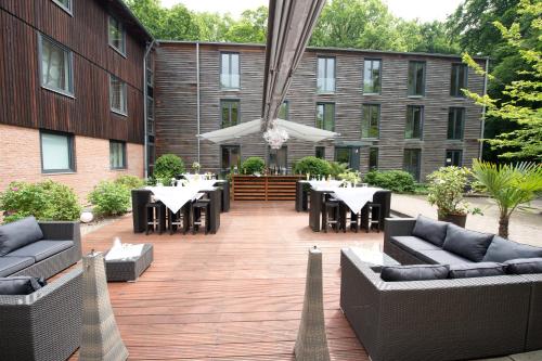 a patio with tables and couches on a building at Bischofshol in Hannover