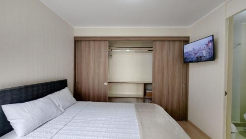 利馬的住宿－Habitación moderna y segura cerca al Aeropuerto，一间卧室设有一张带平面电视的床。