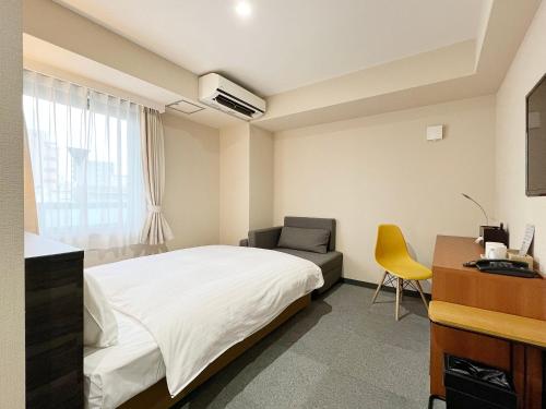 大阪市にあるCHECKinn Osaka Shinimamiyaのベッドとデスクが備わるホテルルームです。