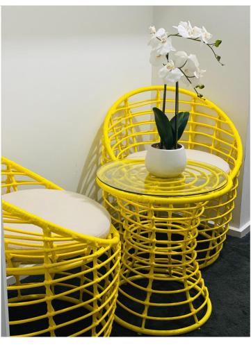 a yellow table and chairs with a plant in a vase at Modern Private room with ensuite in Smithfield