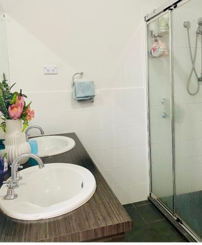een badkamer met 2 wastafels en een douche bij Modern Private room with ensuite in Smithfield