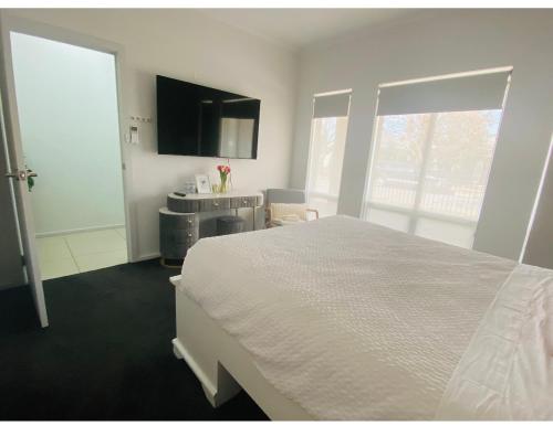 a bedroom with a large white bed and a sink at Modern Private room with ensuite in Smithfield
