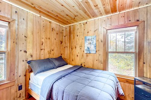 sypialnia z łóżkiem w drewnianej ścianie w obiekcie Dragonfly Gully w mieście Rhinelander