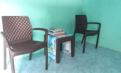 a table with two chairs and a table with books on it at Raja Ampat Sandy Guest House in Saonek