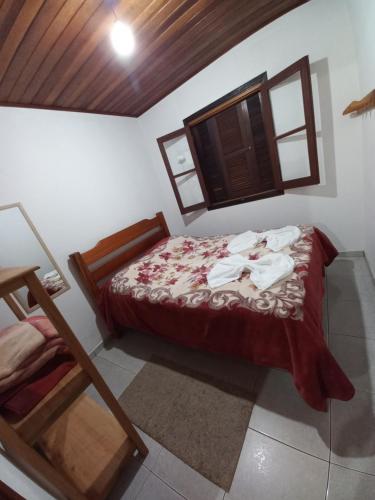 a bedroom with a bed in a room with a window at Chalés lima in Monte Verde