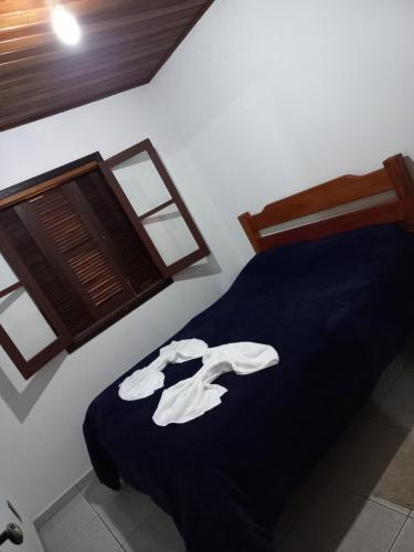 a bedroom with a blue bed in a room at Chalés lima in Monte Verde