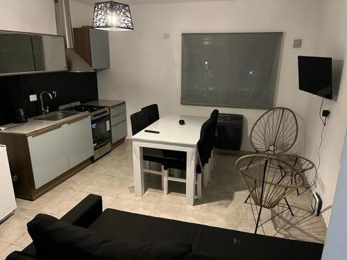a living room with a white table and a kitchen at Travel Suites Ezeiza- 5 pax- Centro Eze- Shoppings a 8 min in Ezeiza