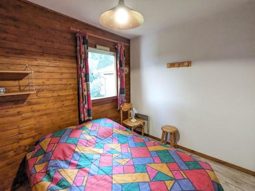 a bedroom with a colorful quilt on a bed at Appartement La Clusaz, 2 pièces, 6 personnes - FR-1-459-219 in La Clusaz