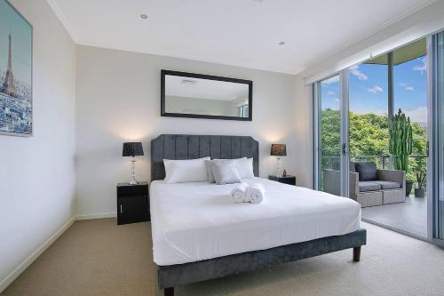 a bedroom with a bed with two towels on it at Top of Taringa Penthouse with Sweeping Views in Brisbane