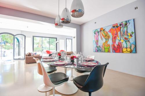 une salle à manger avec une table et des chaises et un tableau dans l'établissement Villa Notre-Dame - Piscine parking 4 chambres, à Marseille
