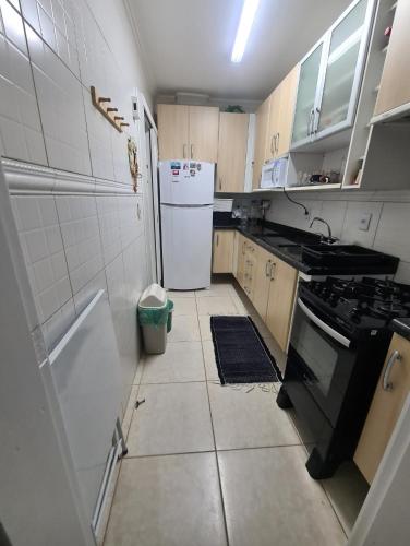 a small kitchen with a stove and a refrigerator at Apartamento Beira mar Capão da Canoa in Capão da Canoa