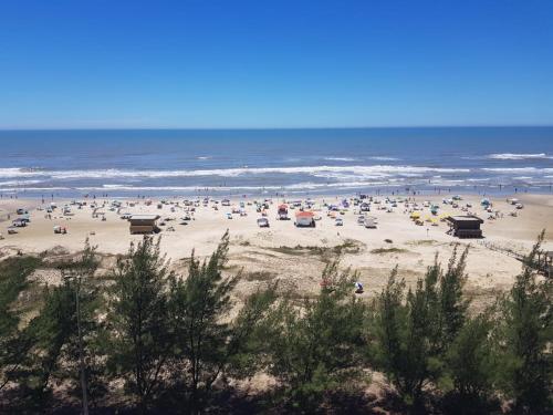 a large group of people on the beach at Apartamento Beira mar Capão da Canoa in Capão da Canoa