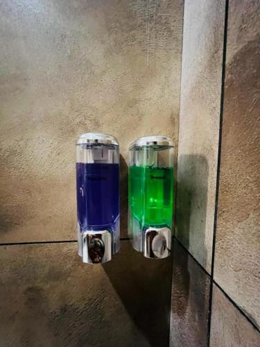two glasses of blue and green liquid sitting on the floor at Pabis luxurious stay in Vythiri