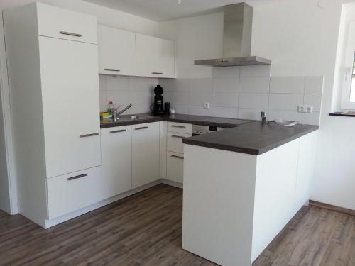 a kitchen with white cabinets and a black counter top at Teck-Apartment in Kirchheim unter Teck