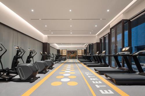 a gym with treadmills and elliptical machines at Citadines Hope City Boao in Qionghai