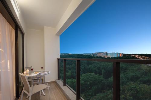 a room with a table and a large window at Citadines Hope City Boao in Qionghai