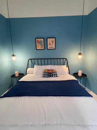 una camera da letto con un letto con pareti blu e due lampade di Casa Bonita: Stylish, Affordable Home & Mini Pool a Kalasan
