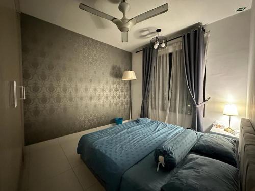 a bedroom with a bed with a blue comforter at The Heights Residence Condo Ayer Keroh Melaka WIFI 100mbps in Ayer Keroh