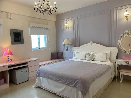 a bedroom with a large white bed and a chandelier at Full House in Magong