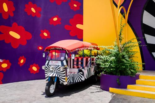 a food cart parked in front of a wall with flowers at The Fig Lobby in Bangkok