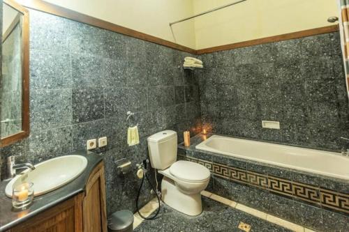 ein Badezimmer mit einem WC, einem Waschbecken und einer Badewanne in der Unterkunft Hidden Paradise - Budi Susanto in Kalasan
