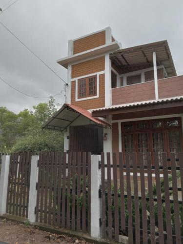 a house with a wooden fence in front of it at Windy Hanthana in Kandy