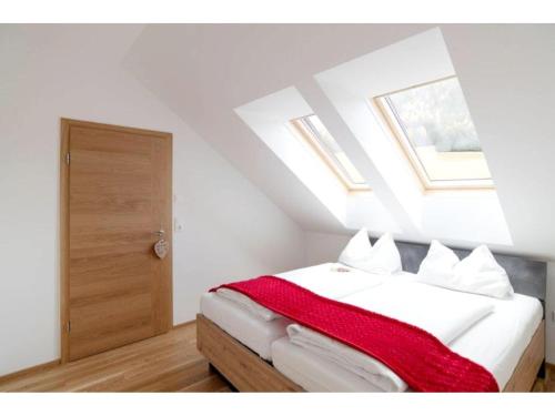 Apartment in Hohentauern with sauna في هوهنتاورن: غرفة نوم مع سرير مع بطانية حمراء عليه