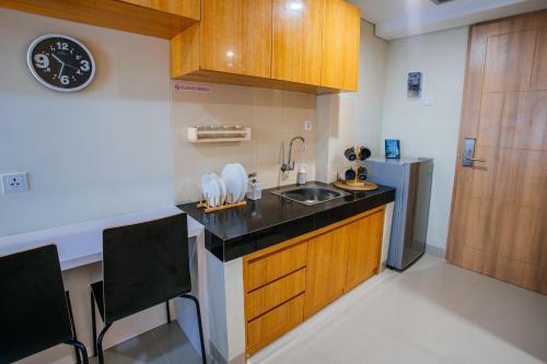 a small kitchen with a sink and a refrigerator at Padina Soho And Residence in Kebonbesar