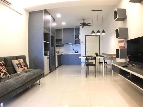 a living room and kitchen with a couch and a table at DaMen Homestay @SubangHomeStay in Subang Jaya