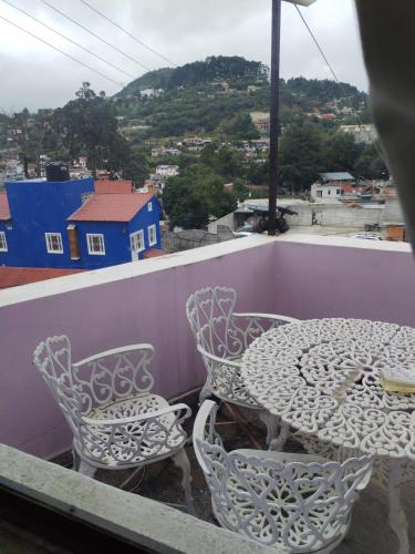 a table and chairs on a balcony with a view at Casa Lila in Mineral del Monte
