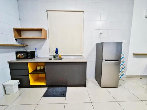 a small kitchen with a sink and a refrigerator at DaMen Homestay @SubangHomeStay in Subang Jaya