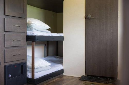 um beliche com almofadas brancas num quarto em Natural farm Zanpa -SEVEN Hotels and Resorts- em Yomitan