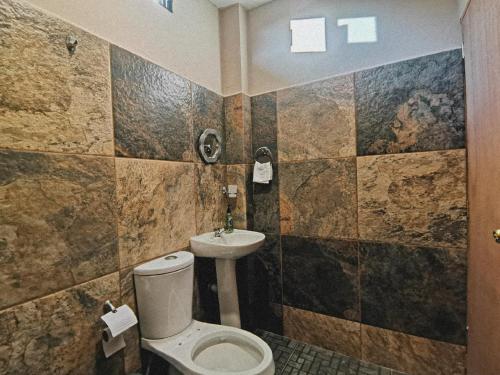 La salle de bains est pourvue de toilettes et d'un lavabo. dans l'établissement CASA EBANO, à Zipolite