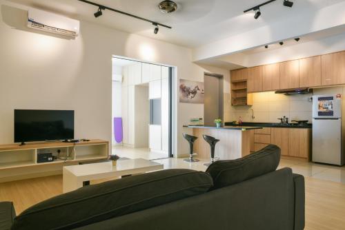 a living room with a couch and a kitchen at USJ One HomeStay @ Subang HomeStay in Subang Jaya